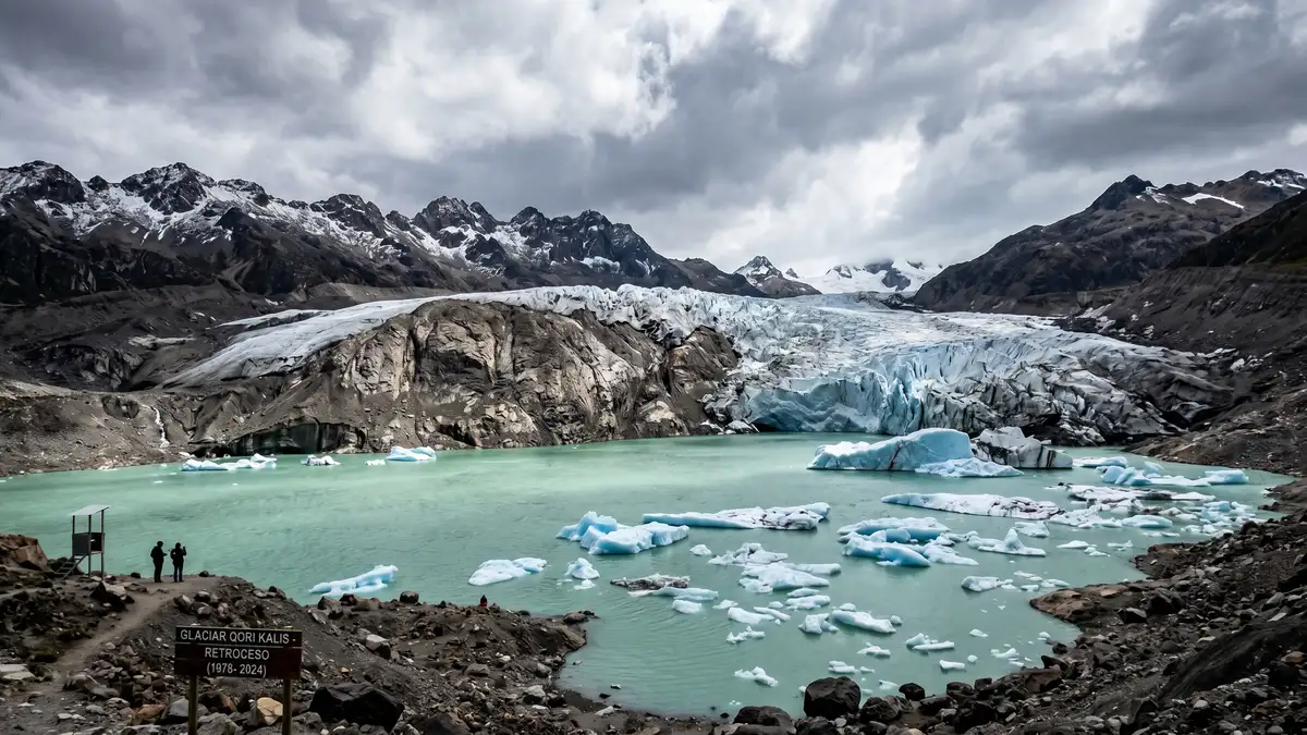 Retreating glacier with exposed rock face and turquoise meltwater pooling at the base showing the reality of global warming and accelerating ice loss